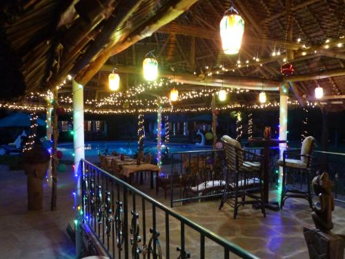 a restaurant with christmas lights and a bar at Residence Maison Müge in Kilifi