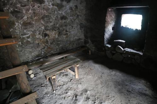 a dark room with a bench and a window at N&N Guest House in Mestia