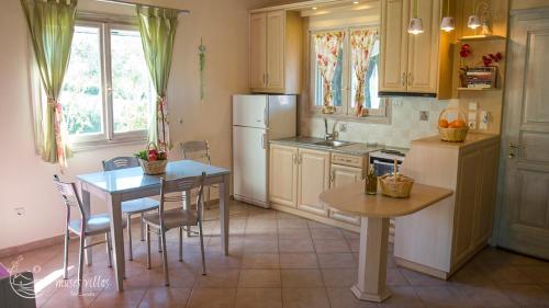 a kitchen with a table and chairs and a refrigerator at Muses Villas in Finikounta