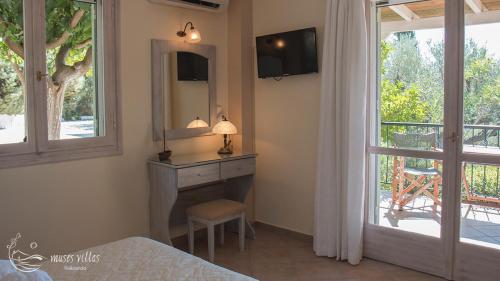 a bedroom with a fireplace and a mirror and a window at Muses Villas in Finikounta