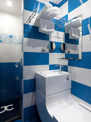 a blue and white bathroom with a sink and a shower at JC Rooms Chueca in Madrid
