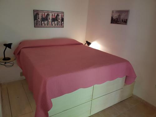 ブドーニにあるDomus Budoni 1のベッドルーム1室(ピンクの毛布付きのベッド1台付)