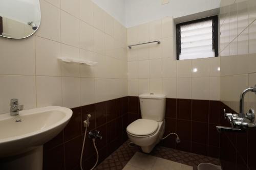 a bathroom with a toilet and a sink at KV Residency in Coimbatore
