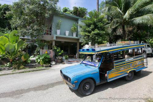 a blue bus parked in front of a building at Home Phang-Nga Guesthouse in Phangnga