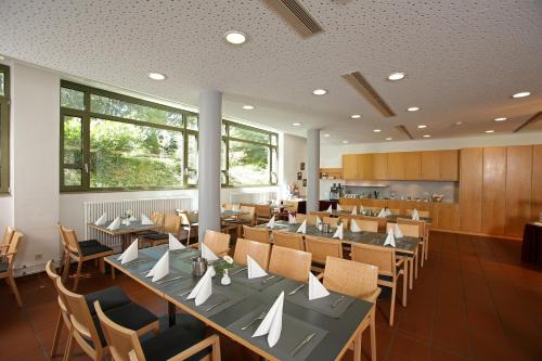 a kitchen filled with tables and chairs and a large window at Christkönigshaus in Stuttgart