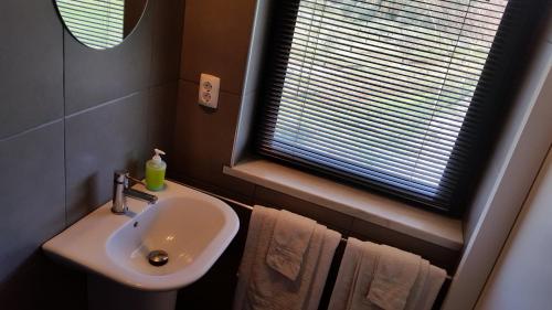 a bathroom with a sink and a window with towels at o vale da mudança in Monte da Pedra Alva