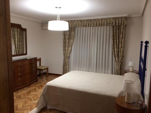 Un pat sau paturi într-o cameră la Apartamentos Alameda