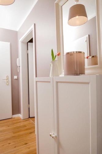 a room with a white cabinet with a vase on it at Ferienwohnung Sonnenblick in Zingst