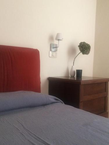 een slaapkamer met een bed en een tafel met een plant bij Casa Angiola in Cagli