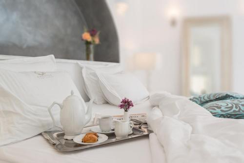 a tray with a tea set on a bed at Anteliz Suites in Fira