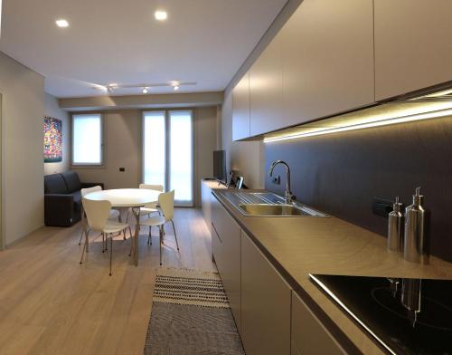 eine Küche mit einem Waschbecken und einem Tisch mit Stühlen in der Unterkunft Suite Porta Romana #2 in Mailand
