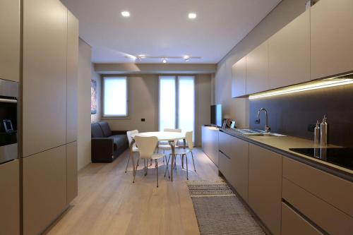 eine Küche mit einem Tisch und Stühlen sowie ein Wohnzimmer in der Unterkunft Suite Porta Romana #2 in Mailand