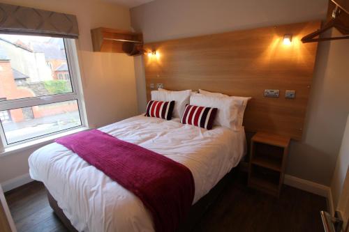 a bedroom with a large bed with a large window at Maryville Apartment by Townlets in Belfast