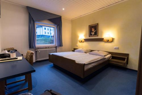 ein Hotelzimmer mit einem Bett und einem Fenster in der Unterkunft Hotel Kupper in Eppenbrunn