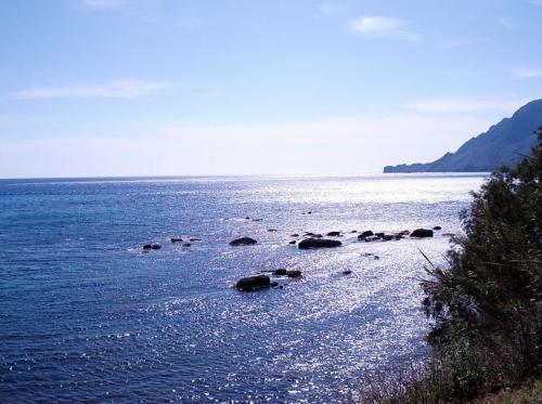 a large body of water with rocks in it at Skinos Apartments in Plakias