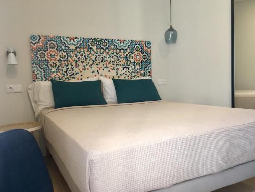 a bedroom with a white bed with a floral headboard at MD Design Hotel - Portal del Real in Valencia