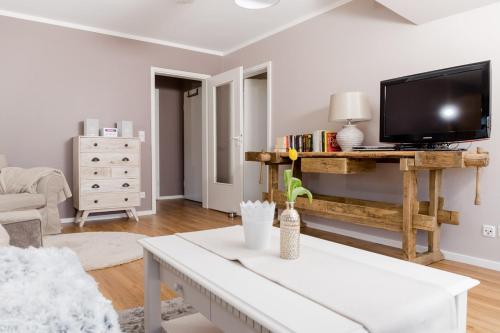 un soggiorno con un tavolo e una TV di Ferienwohnung Sonnenblick a Zingst