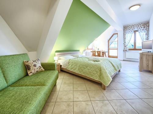 ザコパネにあるVisitZakopane - Avocado Apartmentのベッドルーム(緑のベッド1台、ソファ付)