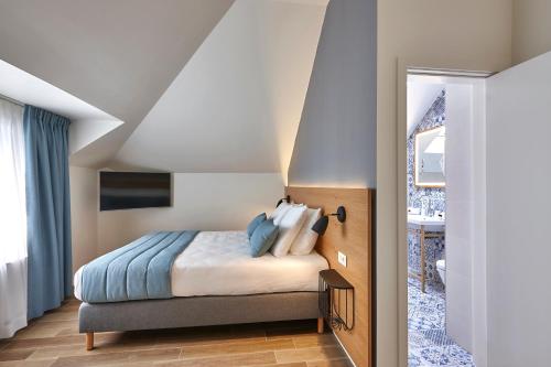 a bedroom with a bed with blue pillows at Hygge Hotel in Brussels