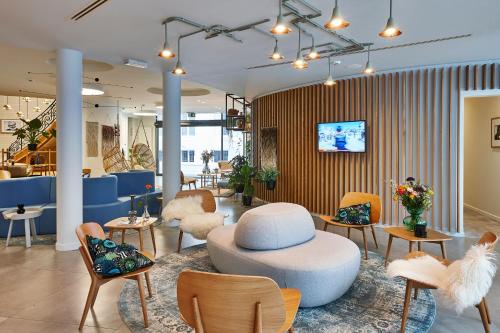 a lobby with a hat on a table and chairs at Hygge Hotel in Brussels