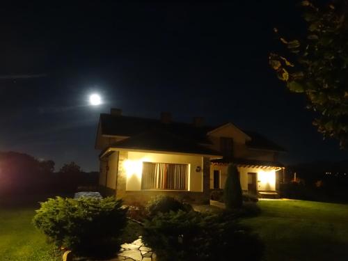 a house at night with the moon in the sky at Apartamentos La Cruz de Paderne in Navia