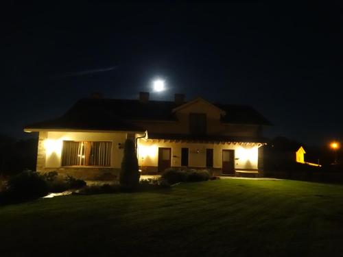 a house with a moon on the roof at night at Apartamentos La Cruz de Paderne in Navia