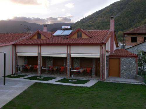 a house with a roof with a table and chairs at To Konaki in Kato Loutraki