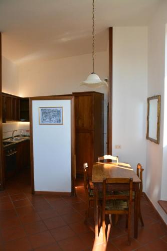 - une cuisine et une salle à manger avec une table et des chaises dans l'établissement Palazzo Calocci appartamenti in Assisi, à Assise