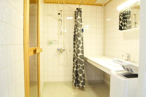 La salle de bains est pourvue d'une douche et d'un lavabo. dans l'établissement Torget Apartment Laululinna, à Pori