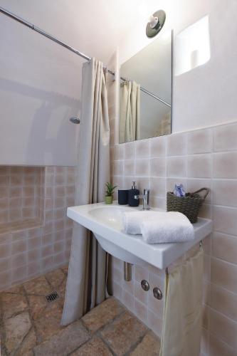 a bathroom with a white sink and a mirror at Corte dei melograni-Suite familiare-zona Ostuni in Montalbano