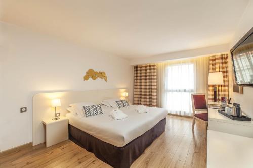 a hotel room with a large bed and a window at Hôtel Montaigne & Spa - Cannes Centre in Cannes