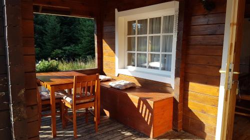 einen Tisch und Stühle auf der Veranda einer Hütte in der Unterkunft Chalet Taffski in Borowez