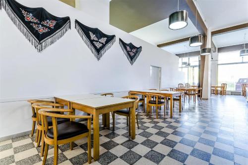ein Esszimmer mit Tischen und Stühlen und einem karierten Boden in der Unterkunft Residencial Jardim da Amadora in Amadora