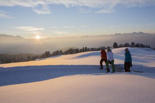 three people standing on top of a snow covered hill at Gasthof Waldesruh in Oetz