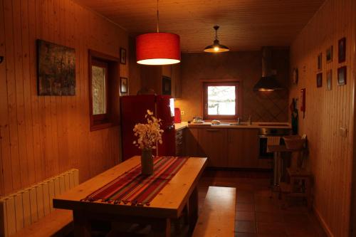 eine Küche mit Holztisch und Kühlschrank in der Unterkunft Casa da Branda St.António in Branda de Santo António