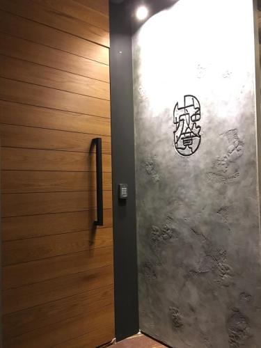 a door with a painting on the side of a wall at Something Easy Inn in Jiufen