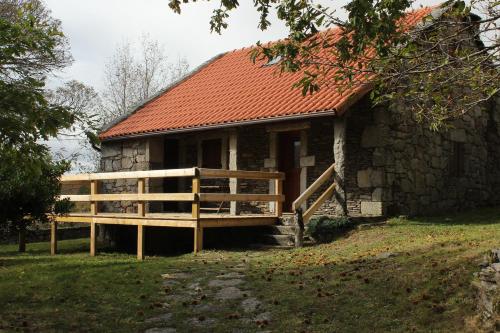 an old stone house with a wooden fence next to it at Casa da Branda St.António in Branda de Santo António