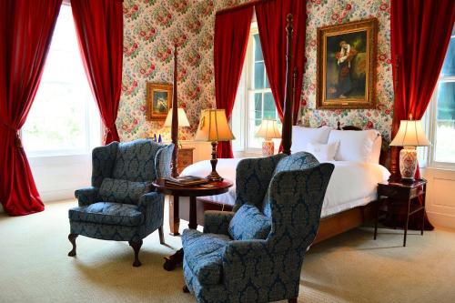 a bedroom with a bed and two chairs at Antrim 1844 in Taneytown