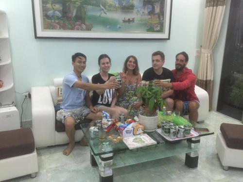 a group of people sitting around a coffee table at Cat Ba Central Homestay in Cat Ba