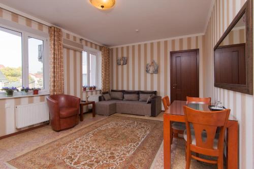 a living room with a couch and a table and chairs at Klassik Hotel in Chişinău