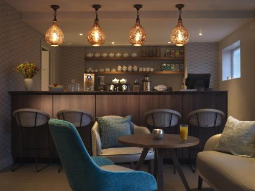 a restaurant with a table and chairs and a bar at The Lygon Arms - an Iconic Luxury Hotel in Broadway