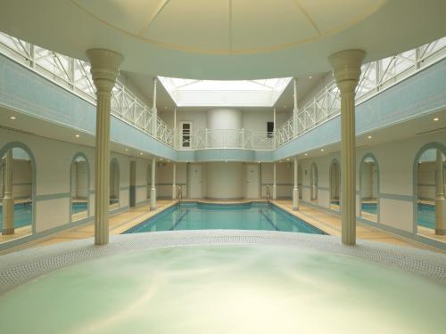 a swimming pool in a large building with a ceiling at The Lygon Arms - an Iconic Luxury Hotel in Broadway