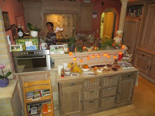 Uma mulher numa cozinha numa casa de bonecas. em B&B 't Hannonshof em Nieuwpoort