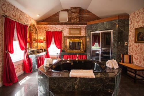 a bathroom with a large tub and red curtains at Antrim 1844 in Taneytown