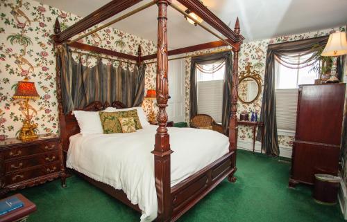 a bedroom with a canopy bed and floral wallpaper at Antrim 1844 in Taneytown