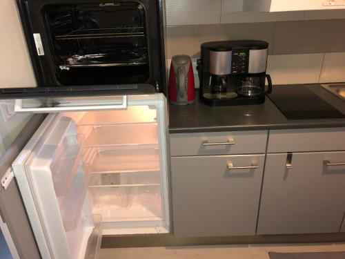 an open refrigerator with its door open in a kitchen at Petit Appartement Jourdan EU in Brussels