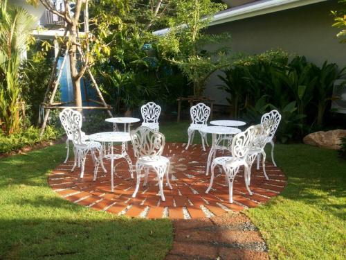 a group of white tables and chairs on a brick patio at Arantarakiri Resort Khao Yai in Mu Si