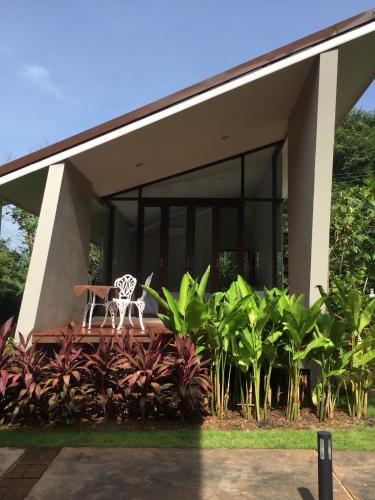 a house with a table and a chair in front of it at Arantarakiri Resort Khao Yai in Mu Si