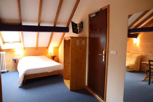 a bedroom with a bed and an open door at La Ferme du Bois Barbu in Villard-de-Lans