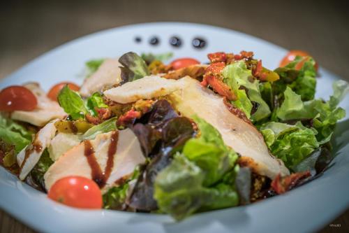 a plate of food with a salad on a table at Archipel Volcans in Saint-Genès-Champanelle